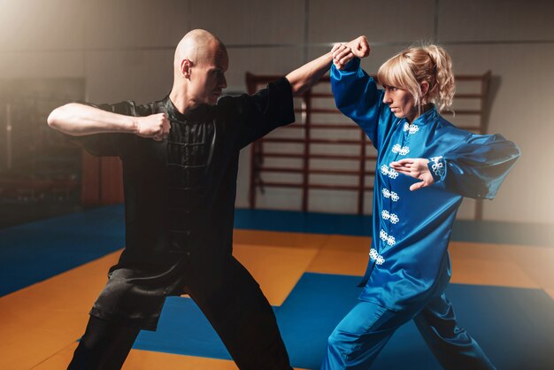 Exercices de combattants wushu masculins et féminins à l'intérieur