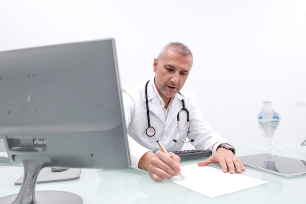 Photo l'expérience d'un médecin caucasien rédige une ordonnance dans un bureau d'hôpital moderne