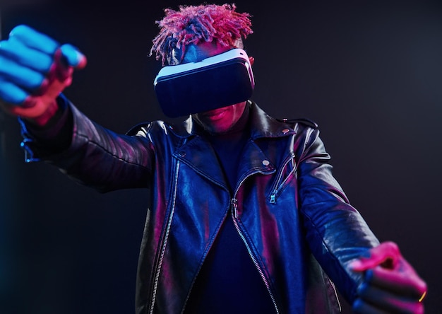 Expérience de réalité virtuelle Éclairage au néon futuriste Jeune homme afro-américain dans le studio