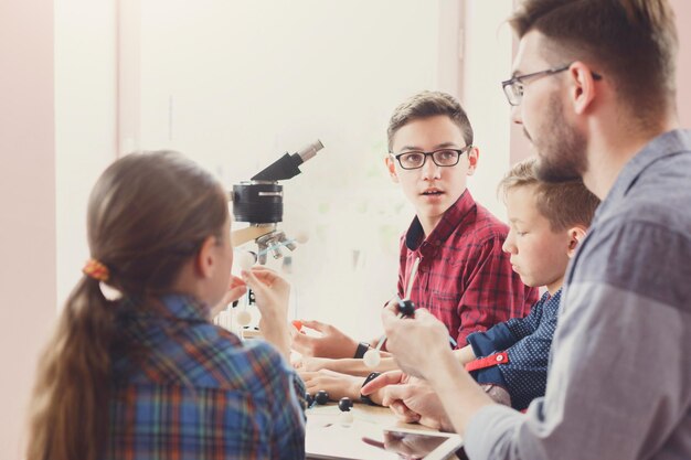 Expériences physiques à l'école, enfants construisant un modèle atomique sur le lieu de travail du laboratoire, espace de copie. L'éducation des tiges. Développement précoce, éducation, bricolage, concept d'innovation.