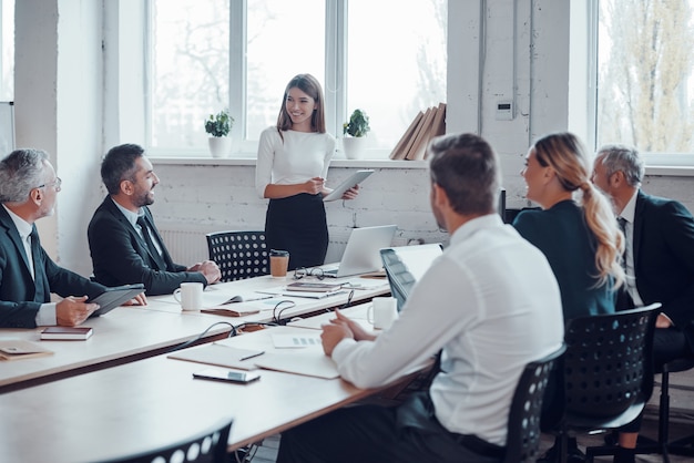 Expert en affaires professionnel organisant une réunion tout en travaillant avec des collègues dans le bureau moderne