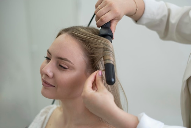 l'expert styliste coiffeur faisant du travail en faisant de belles boucles