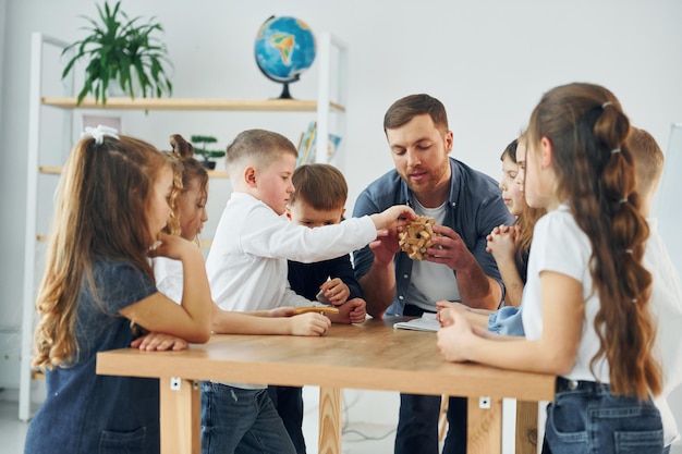 Explorer le jouet de puzzle Groupe d'enfants élèves en classe à l'école avec l'enseignant