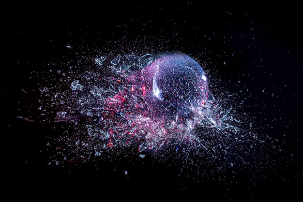 Photo explosion d'une boule de verre sur un fond noir