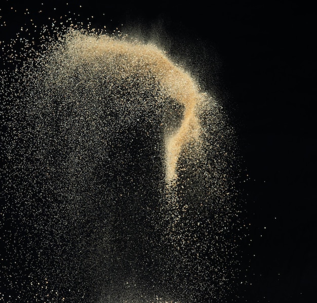 Photo l'explosion du sable volant la vague de sable doré explose les nuages de sable abstraits volent le sable de couleur jaune