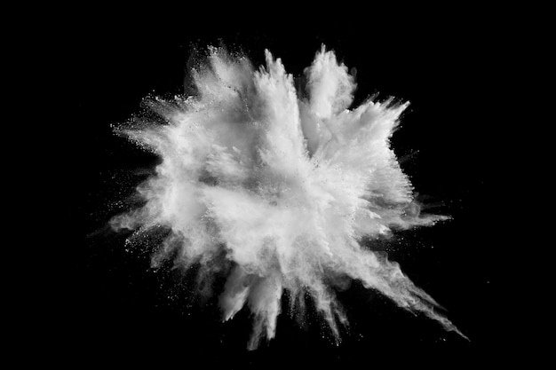 Photo explosion de poudre blanche. figer le mouvement des particules de poussière blanche sur fond noir.
