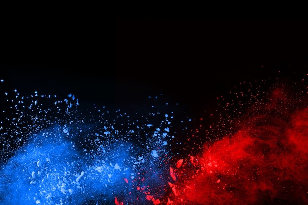 Explosion de poudre de couleur bleue et rouge sur fond noir