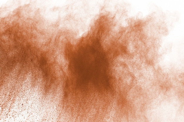 Explosion de poudre de couleur marron sur fond blanc.