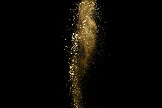 Explosion de poudre dorée sur fond noir.