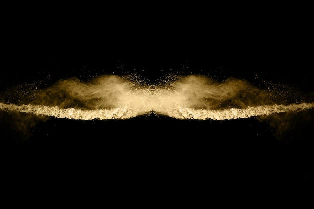 Explosion de poudre d'or sur fond noir. Figer le mouvement.