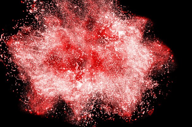 Explosion de poudre rouge sur fond noir.