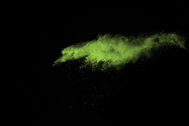 Photo explosion de poussière abstraite gelée verte sur fond noir.