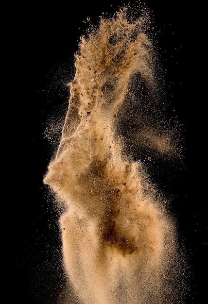 Explosion de sable isolée sur fond sombre, nuage de sable abstrait, flou de mouvement