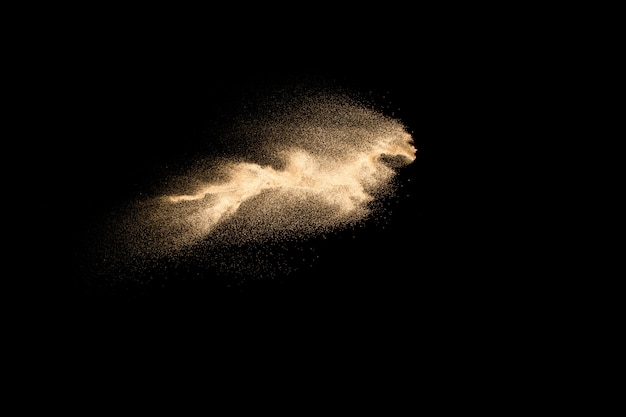 Explosion de sable de rivière à sec isolée sur fond noir. Nuage de sable abstrait