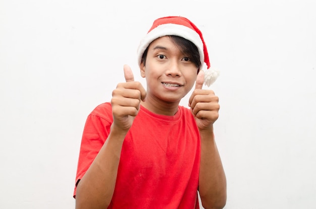 expressif heureux jeune homme asiatique en vêtements de thème de noël santa avec un visage choqué et surpris