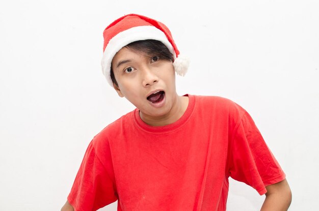 expressif heureux jeune homme asiatique en vêtements de thème de noël santa avec un visage choqué et surpris