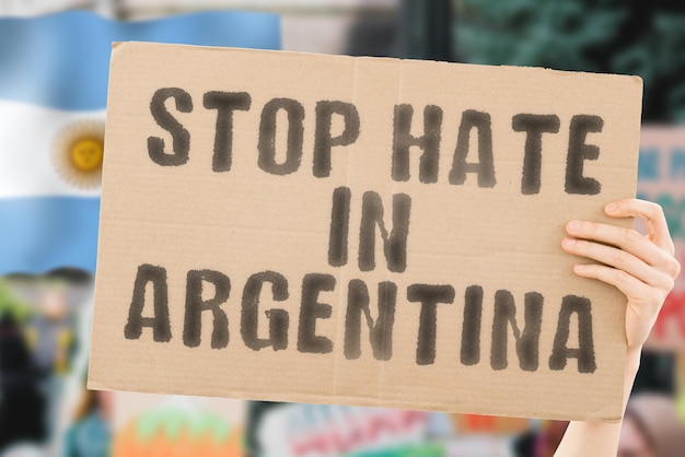 L'expression Arrêtez la haine en Argentine sur une bannière dans la main des hommes avec un drapeau argentin flou en arrière-plan Gay Droits de l'homme Égalité Questions sociales Société Problème Conflit