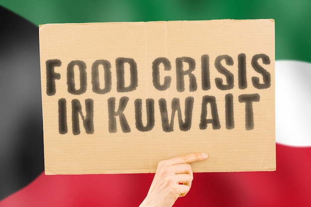 L'expression Crise alimentaire au Koweït est sur une bannière entre les mains des hommes avec un drapeau koweïtien flou en arrière-plan Crise Finance Vie Nutrition Pain Catastrophe Effondrement Problème social