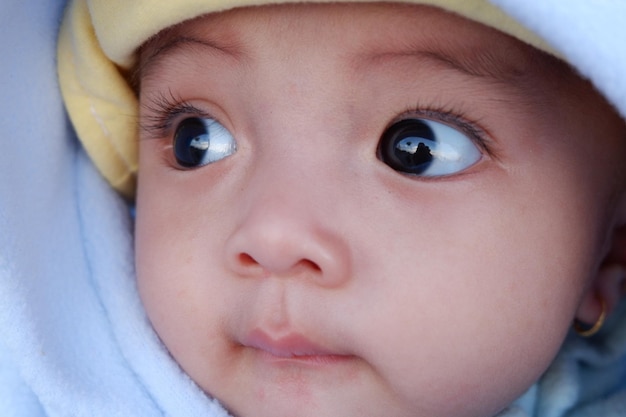 L'expression du bébé lorsqu'il est tenu par sa mère. C'est un bébé mignon.