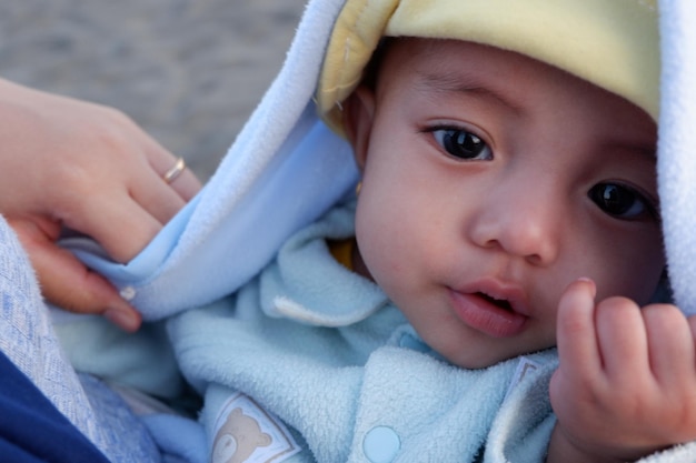 L'expression du bébé lorsqu'il est tenu par sa mère. C'est un bébé mignon.