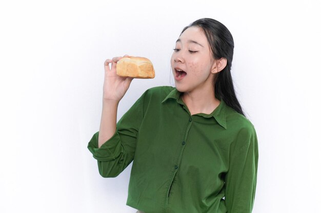 L'expression d'une femme asiatique indonésienne en robe verte va manger du pain