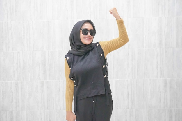Expression d'une femme indonésienne asiatique portant un hijab noir avec des manches jaunes