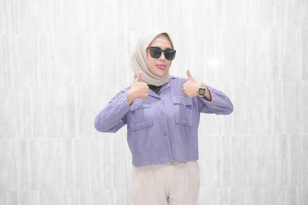 L'expression heureuse d'une femme asiatique indonésienne en hijab portant des vêtements bleus