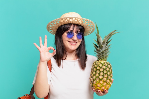 Expression heureuse de femme jeune voyageur et tenant un ananas