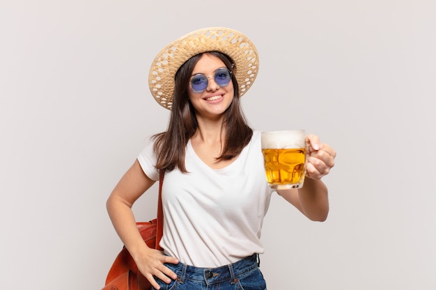 Expression heureuse de femme jeune voyageur et tenant une bière