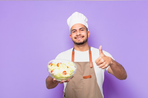 Expression heureuse de jeune homme hispanique. chef avec un concept de salade