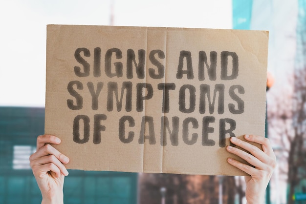 L'expression Signes et symptômes du cancer sur une bannière dans la main des hommes Diagnostic de santé