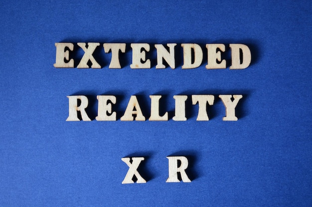 Photo extended reality xr words in wooden alphabet letters isolated on blue background
