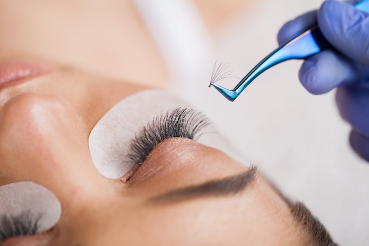 Photo extensions de cils. faux cils. procédure d'extension de cils. styliste professionnel allongeant les cils féminins. maître et client dans un salon de beauté