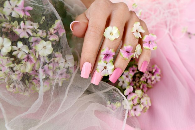 Photo extensions d'ongles sur une forme carrée avec du vernis à ongles rose multicolore