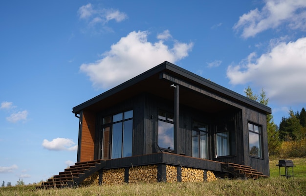 Photo extérieur d'une cabine en bois moderne noire avec espace de copie