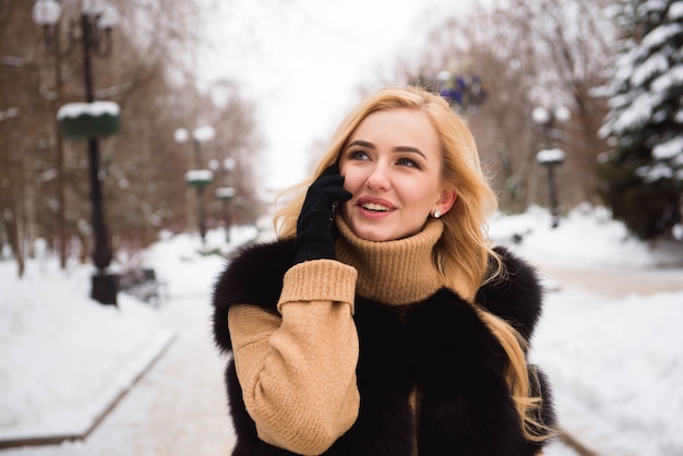 Extérieur en gros plan photo de jeune belle fille souriante heureuse marchant dans la rue en hiver