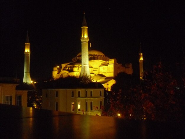 Photo l'extérieur d'une mosquée éclairée contre un ciel clair la nuit