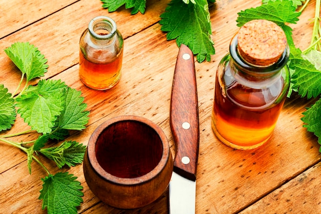 Extrait d'ortie en bouteille et feuilles d'ortie fraîche.Urtica dioica ou ortie cuisante.Herboristerie