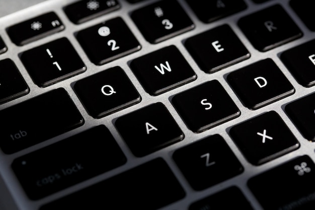 Extreme closeup d'un clavier argent moderne avec des boutons noirs