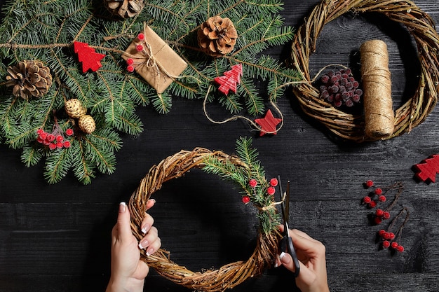 Fabricant de décoration de noël avec leurs propres mains couronne de noël pour les vacances du nouvel an c...