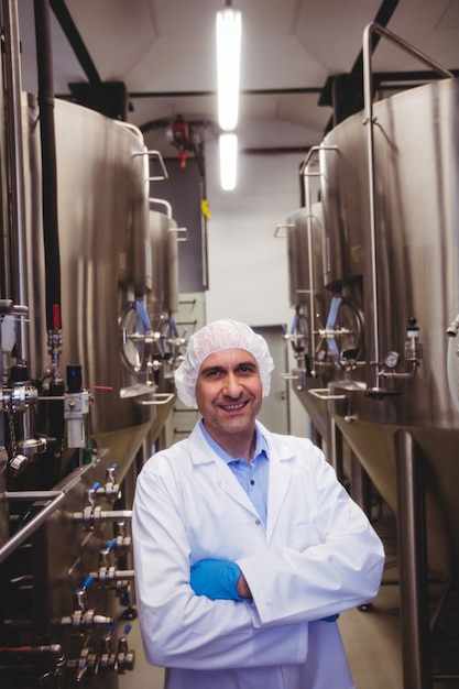 Fabricant souriant, debout dans la brasserie