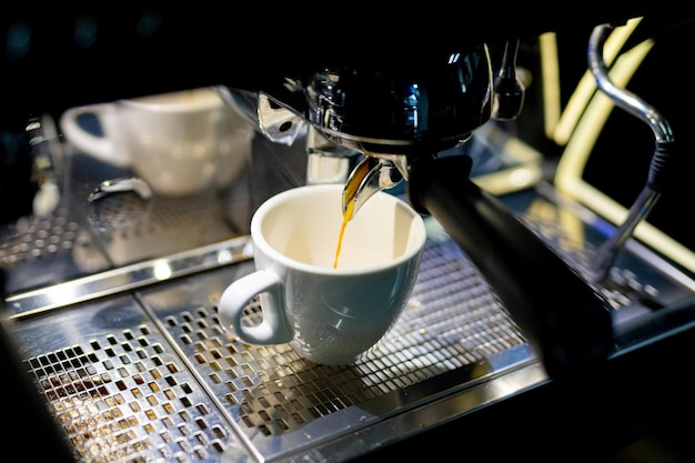 Fabrication d'espresso avec du lait à la cafétéria Fabrication de café par un barista au restaurant