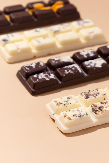 Fabriquer des bonbons au lait blanc et au chocolat noir sur fond beige vue de dessus à plat