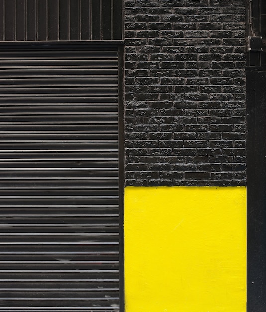 Façade en brique noire et jaune et store de magasin