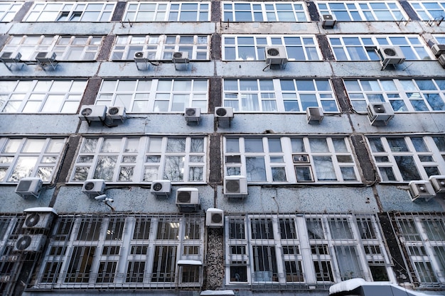 La façade du bâtiment avec de grandes fenêtres et beaucoup de climatisation