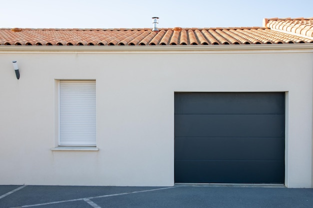 Façade fenêtre blanche volet pvc et porte garage portail sectionnel de maison de banlieue