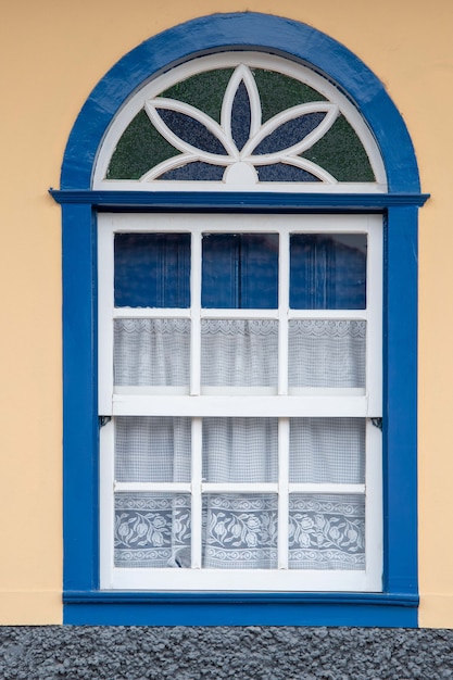 Façade de fenêtre de maison coloniale brésilienne dans un mur jaune