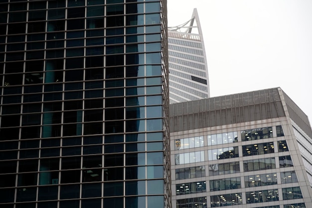 Façade d'un gratte-ciel moderne avec des murs en verre Du dessous d'un grand gratte-ciel contemporain avec des murs en verre contre un ciel nuageux au centre-ville