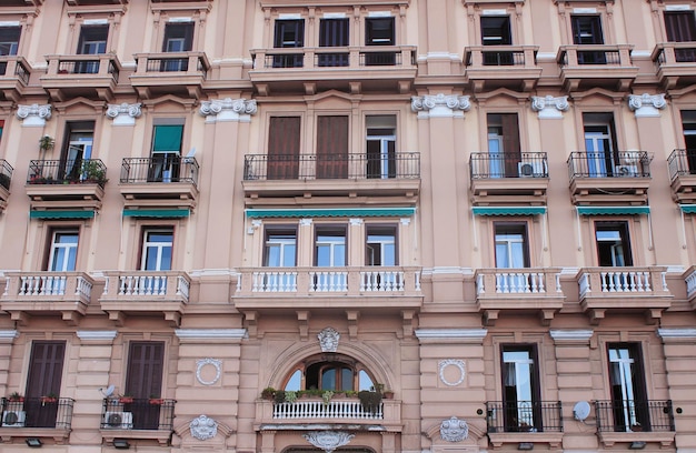 Façade d'un immeuble ancien avec volets et balcons