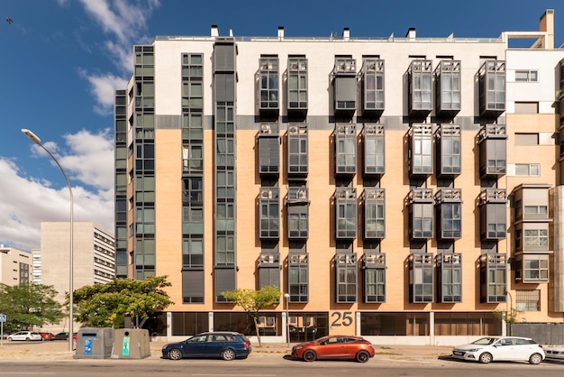 Façade d'un immeuble résidentiel moderne avec des fenêtres en métal noir et en verre par beau temps